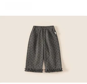 Detail view of girl's grey heart-patterned trousers with elastic waist and ruffled hems
