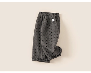 Detail of dark grey girls' pants with heart pattern and ruffled hem on cotton fabric