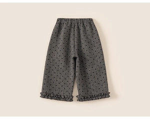 Detail of girls' grey trousers featuring black heart patterns and ruffled cuffs