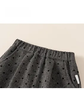 Close-up of elastic waistband on grey heart-patterned trousers with knit fabric detail