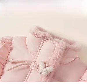 Gros plan d'une veste d'hiver rose pour fille avec col en peluche et bouton nœud élégant