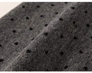 Macro view of grey winter tweed fabric with black polka dots for children trousers