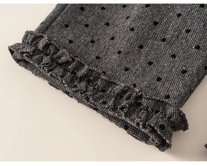 Detail of grey girl's pants showing black heart patterns and ruffled hem edge