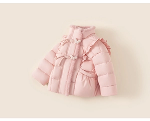 Détail d'un manteau d'hiver rose avec boutons papillon et élégantes finitions volantées