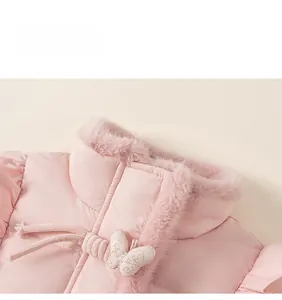 Détail de doudoune rose montrant une boucle nœud brodée et un col en fausse fourrure
