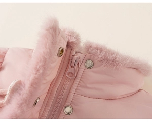 Détail d'une veste d'hiver rose avec col en fausse fourrure douce et boutons-pression