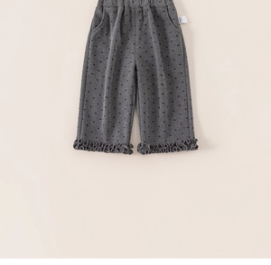 Detail of dark grey kids' trousers with heart prints and ruffled hem edges