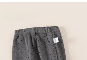 Detail of grey girls trousers with black heart print and elastic waistband feature