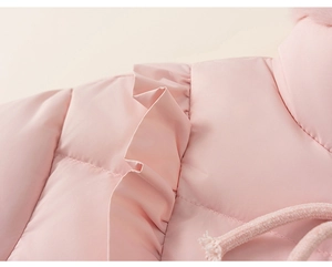 Vue détaillée de la veste d'hiver rose avec bords à volants et texture de tissu coupe-vent