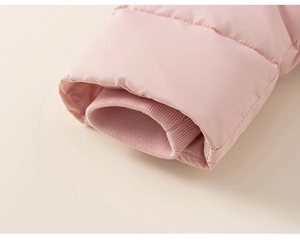 Détail macro d'une manche de veste rose avec poignets coupe-vent en tricot côtelé