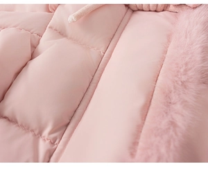 Gros plan du tissu matelassé rose de la doudoune avec col en fausse fourrure