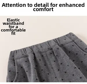 Detail view of elastic waistband on grey knit pants with black heart pattern