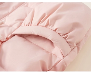 Détail macro d'une doudoune rose d'hiver avec tissu matelassé mat et poche moelleuse