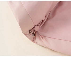 Détail de la doudoune rose avec cordon de serrage et texture de tissu mate douce