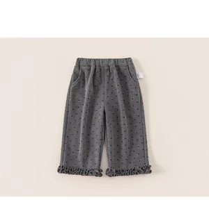 Detail of dark grey girls' pants with heart prints, elastic waist and ruffled cuffs