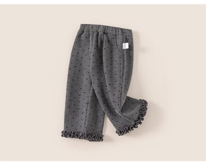 Detail view of girls gray knit pants with black heart patterns and ruffled hem design
