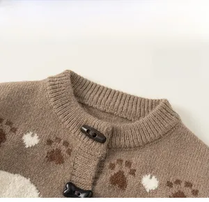 Detail of a brown knit cardigan with classic round neck and bone-shaped toggle buttons