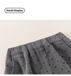Detail of gray girls' knit pants showing elastic waistband and black heart pattern