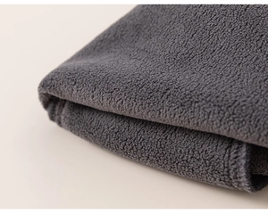 Detailed close-up of dark grey soft fleece fabric and high-quality edge stitching for girls' pants