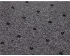 Macro detail of dark grey fleece fabric featuring black heart polka dots for girls' pants