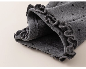 Detail of dark grey heart print leggings featuring warm fleece lining and ruffled hems