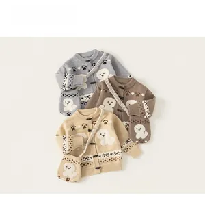Detailed close-up of baby knit cardigans with matching crossbody bags in neutral tones