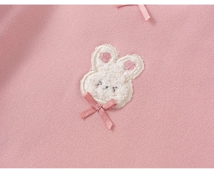 Detailopname van 3D konijnenpatch en roze strik op zacht shirt met lange mouwen voor