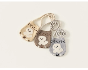 Close-up of three knit shoulder bags with cute dog patterns in cream, brown and gray