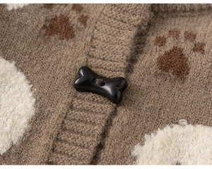 Detail of soft brown knit cardigan featuring claw patterns and unique bone-shaped button