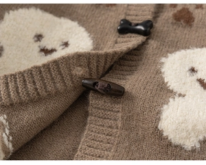 Detail of brown knit cardigan featuring plush bear patch and wooden toggle buttons