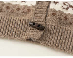 Detailed macro view of warm brown knit cardigan with horn button and snowflake patterns