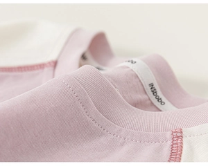 Detailed macro view of children's cotton tee neckline with pink contrast stitching