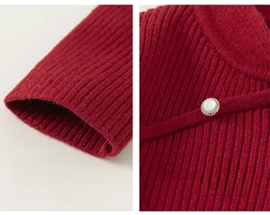 Detail of red ribbed knit sweater featuring vintage pearl button and elastic cuffs