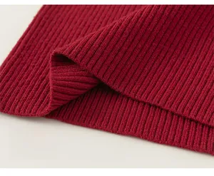 Detailed macro view of dark red ribbed knit fabric on a girls sweater hemline