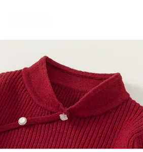 Close-up of red knit sweater featuring a mandarin collar and pearl button details
