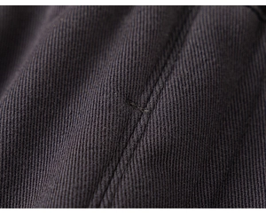 Detaillierte Makroansicht von dunkelblauem Twill-Baumwollstoff und präzisen Nähten der Hose