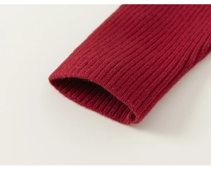 Detailed macro shot of red ribbed knit cuffs on a girl's sweater showing fabric texture