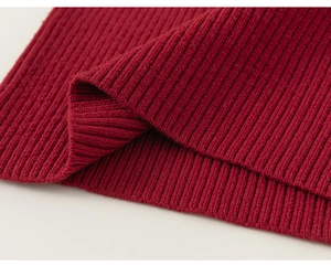Macro detail of wine red ribbed knit fabric texture on the girls long sleeve sweater