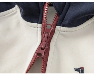 Détail de veste à capuche pour fille avec zip en résine à double sens et motif de chien