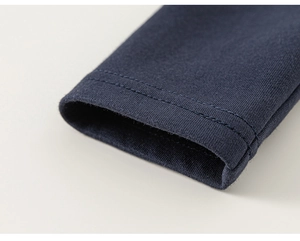 Détail de la manche d'un sweat bleu marine montrant la double couture et la texture du tissu