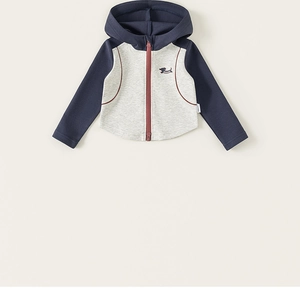 Détail de veste à capuche enfant avec manches contrastées et logo chien brodé