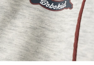 Gros plan sur la maille chinée grise avec logo Bobokid et détails de passepoil rouge