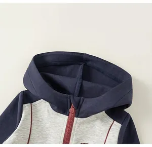 Détail de la capuche et coutures contrastées sur la veste de sport pour enfants