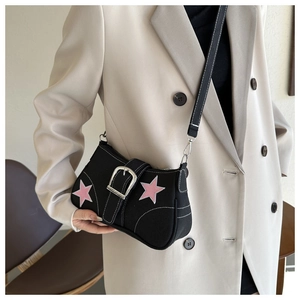 Detail of black canvas underarm bag with pink stars and a large silver buckle