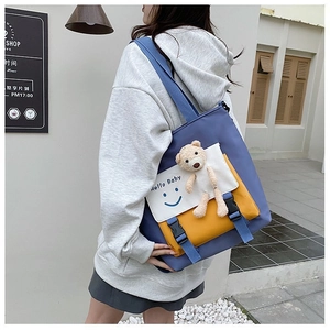 Detail shot of a color-block canvas tote bag with 3D plush bear and Hello Baby print