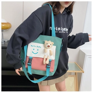 Close-up of contrast color canvas tote with Hello Baby print and cute plush bear charm