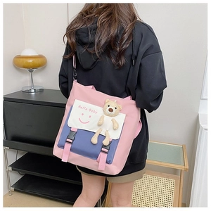 Detail of color-block canvas tote bag with Hello Baby print and cute bear plush pendant