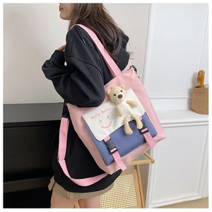 Detail of multi-color tote bag with plush bear, pink shoulder strap and buckle closure