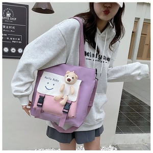 Detail of color-block tote bag featuring a cute bear doll and Hello Baby print