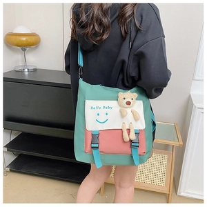 Detail of color-block canvas messenger bag with Hello Baby print and cute plush bear charm